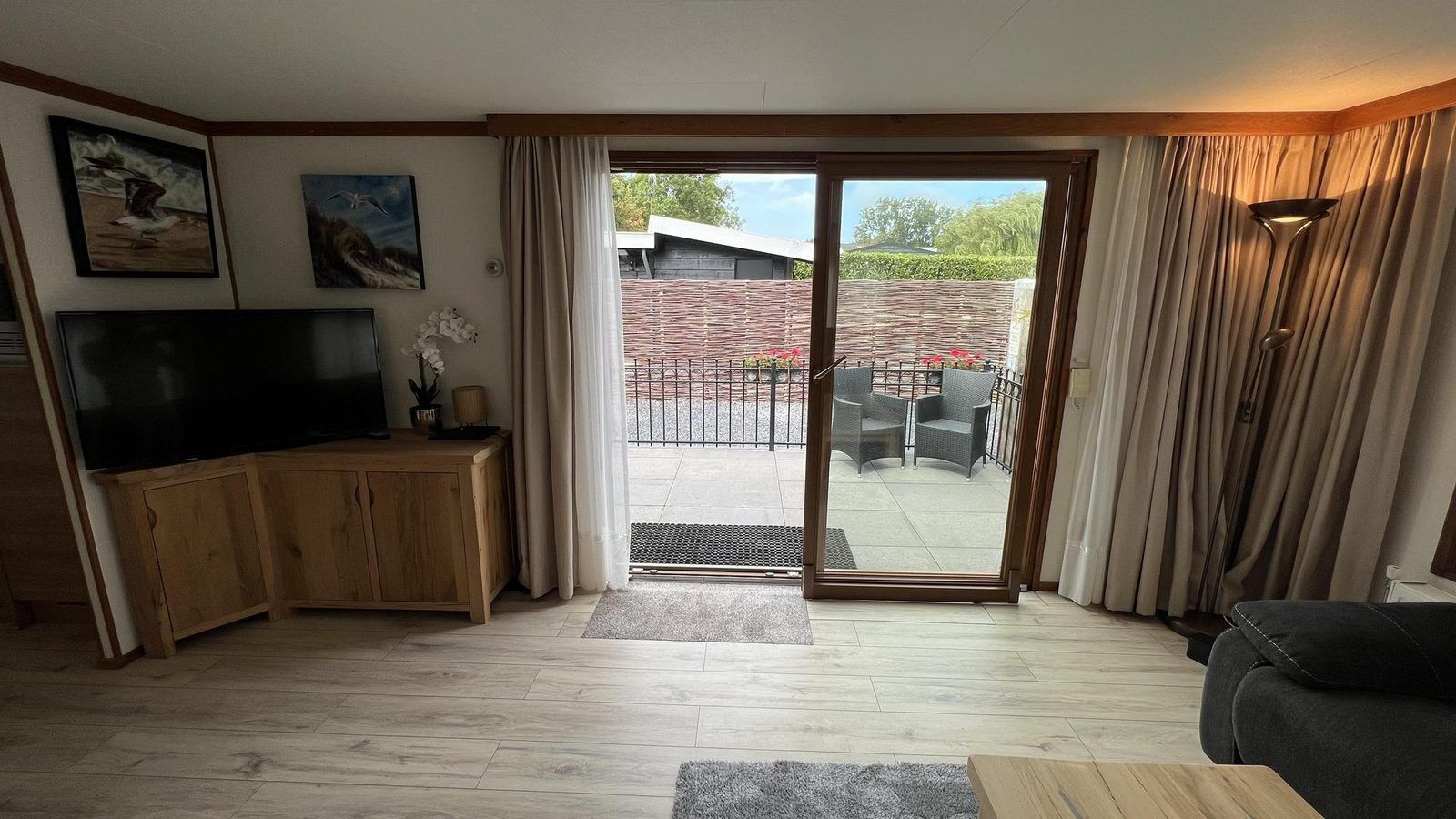 Uitzicht vanuit de woonkamer op het terras van VZ2321 Vakantiechalet in Renesse, Zeeland.