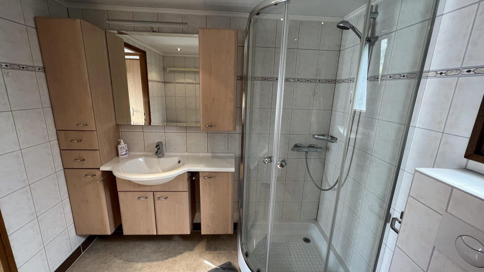 Moderne badkamer in VZ2321 Vakantiechalet in Renesse met douche en wastafel in Zeeland.