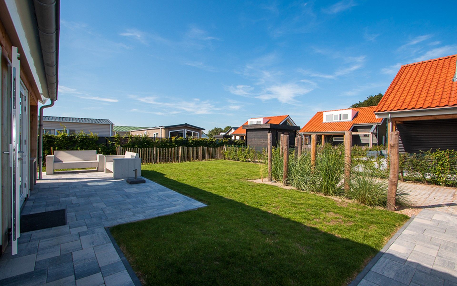 Zonnig terras bij Vakantiehuis Zonnedorp 28 in Renesse, omgeven door natuur.