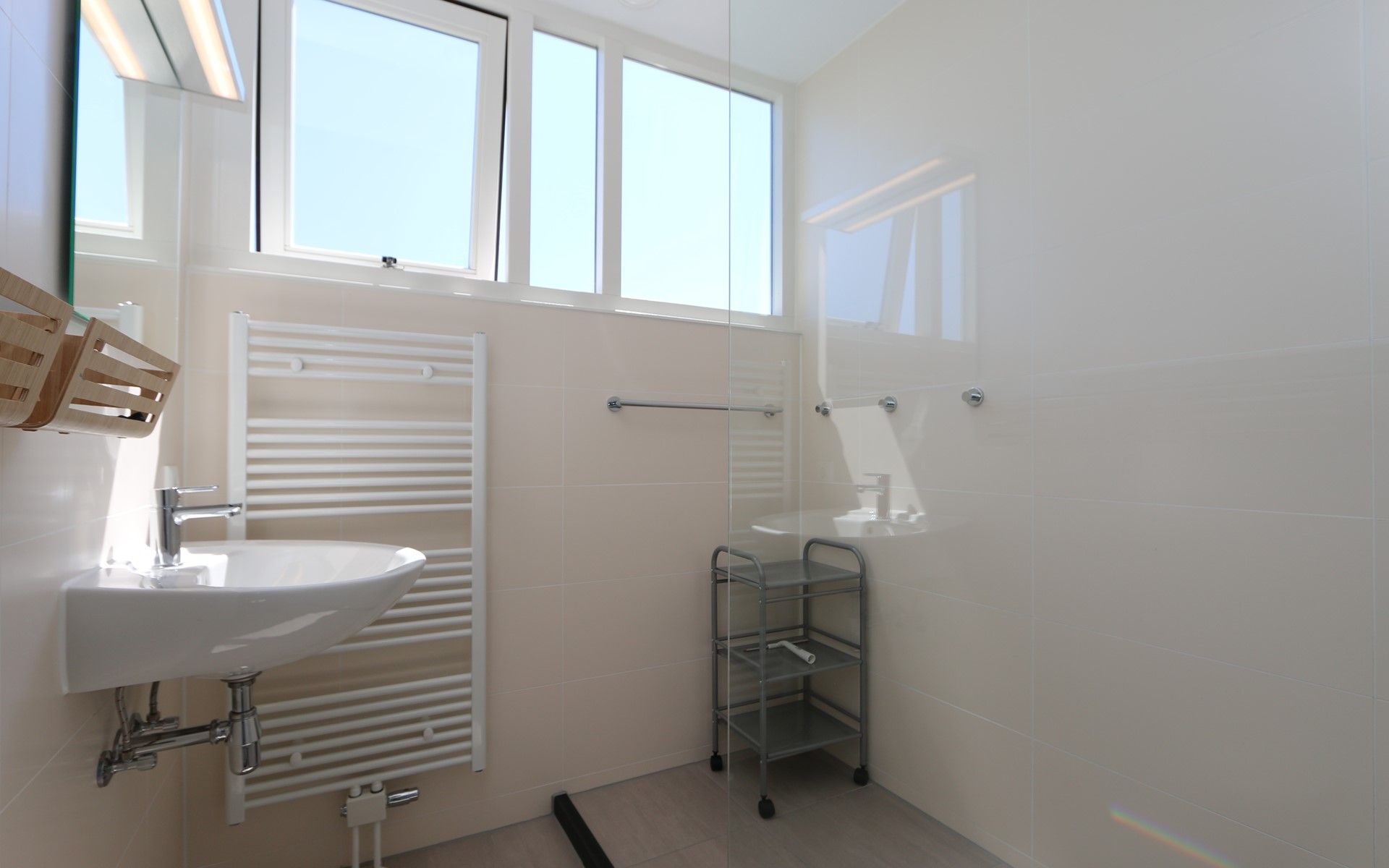 Lichte badkamer met grote ramen in Het Witte Strandhuis in Renesse, Zeeland.