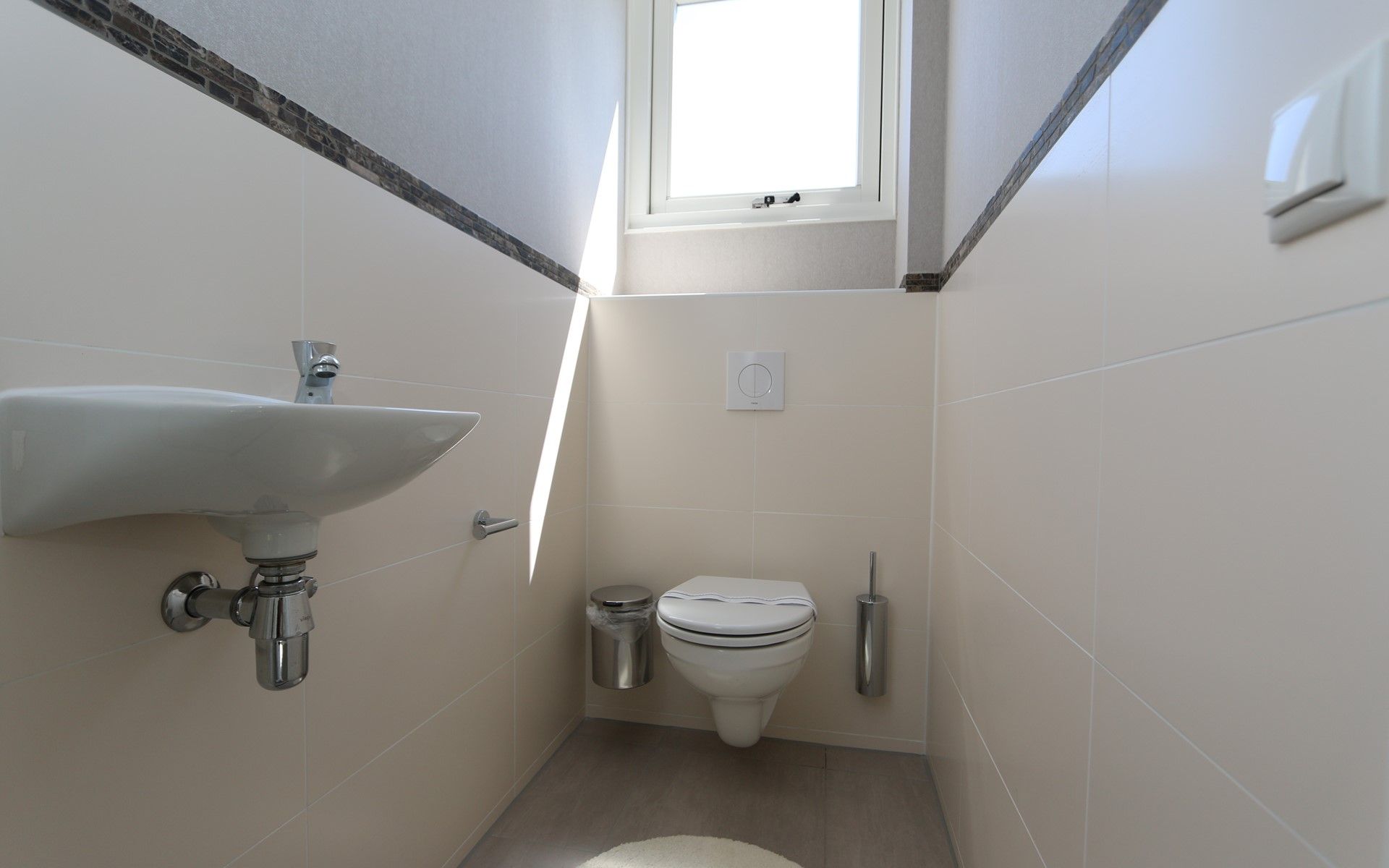 Stijlvol toilet met natuurlijk licht in Het Witte Strandhuis in Renesse, Zeeland.