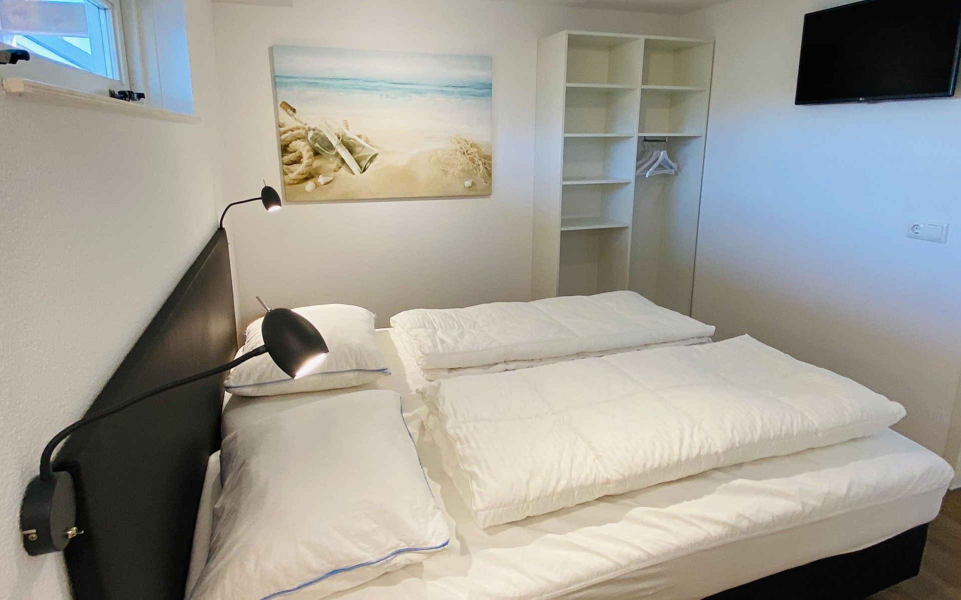 Modernes Schlafzimmer mit Kunstwerken im Ferienhaus Zonnedorp 29 Strandloper, Renesse, Zeeland.