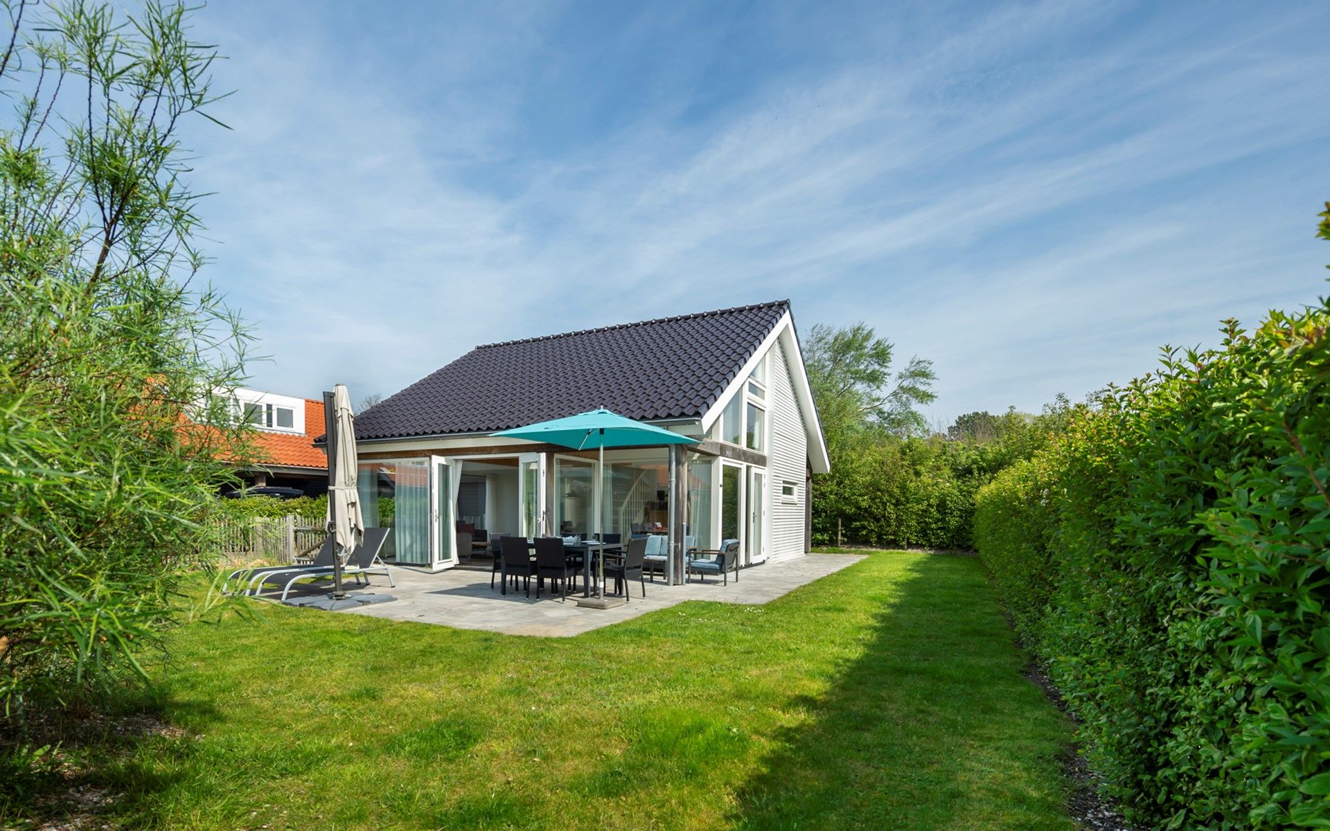Vakantiehuis Zonnedorp 27 Beach Villa Renesse met zonnig terras en groene tuin.