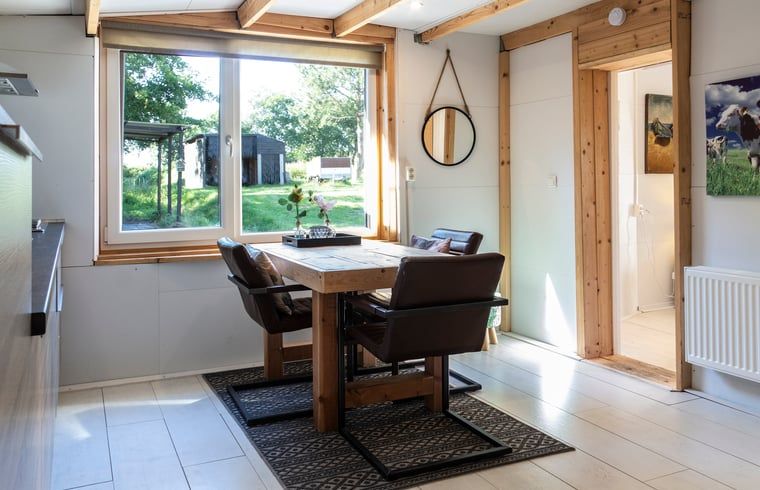 Dining room overlooking the garden in Huisje in Renesse, a vacation home in beautiful Zealand.