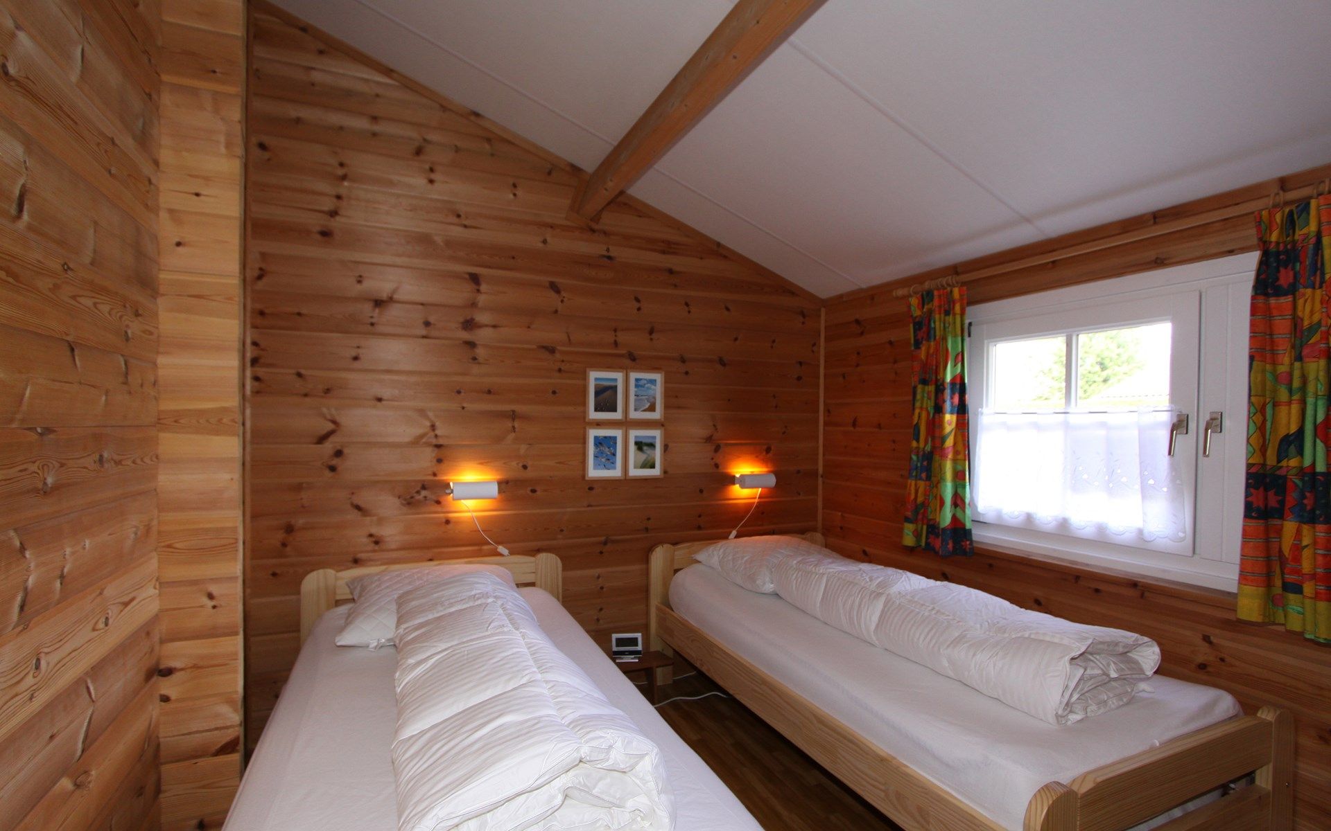 Vacation bungalow Beachpark 42 in Renesse, bedroom with two single beds and warm wooden walls.