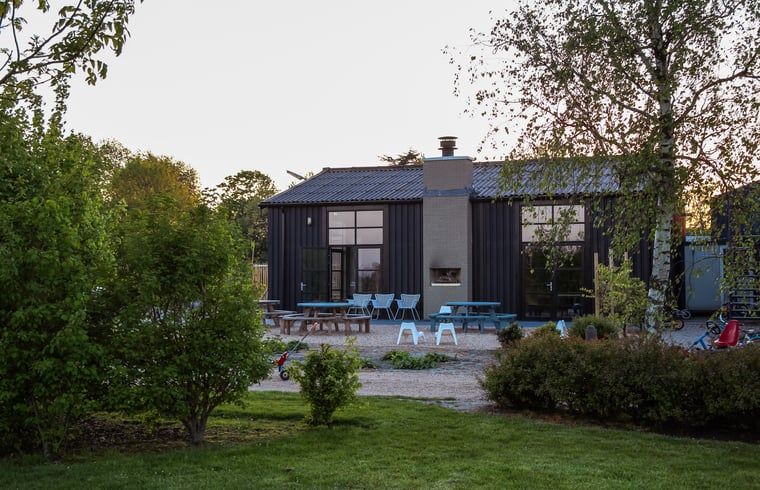 Aussenansicht des Ferienhauses in Looperskapelle, Zeeland, mit grossem Garten und Sitzbereich.