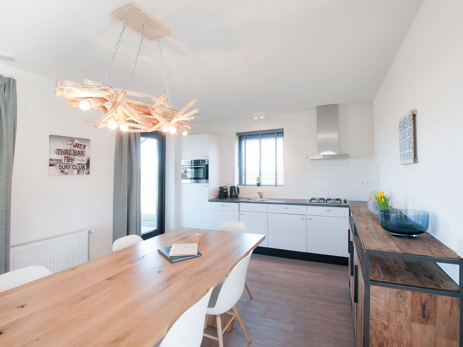 Cozy dining room in Holiday home Oesterdam Resort, Tholen with wooden table and modern lamp.