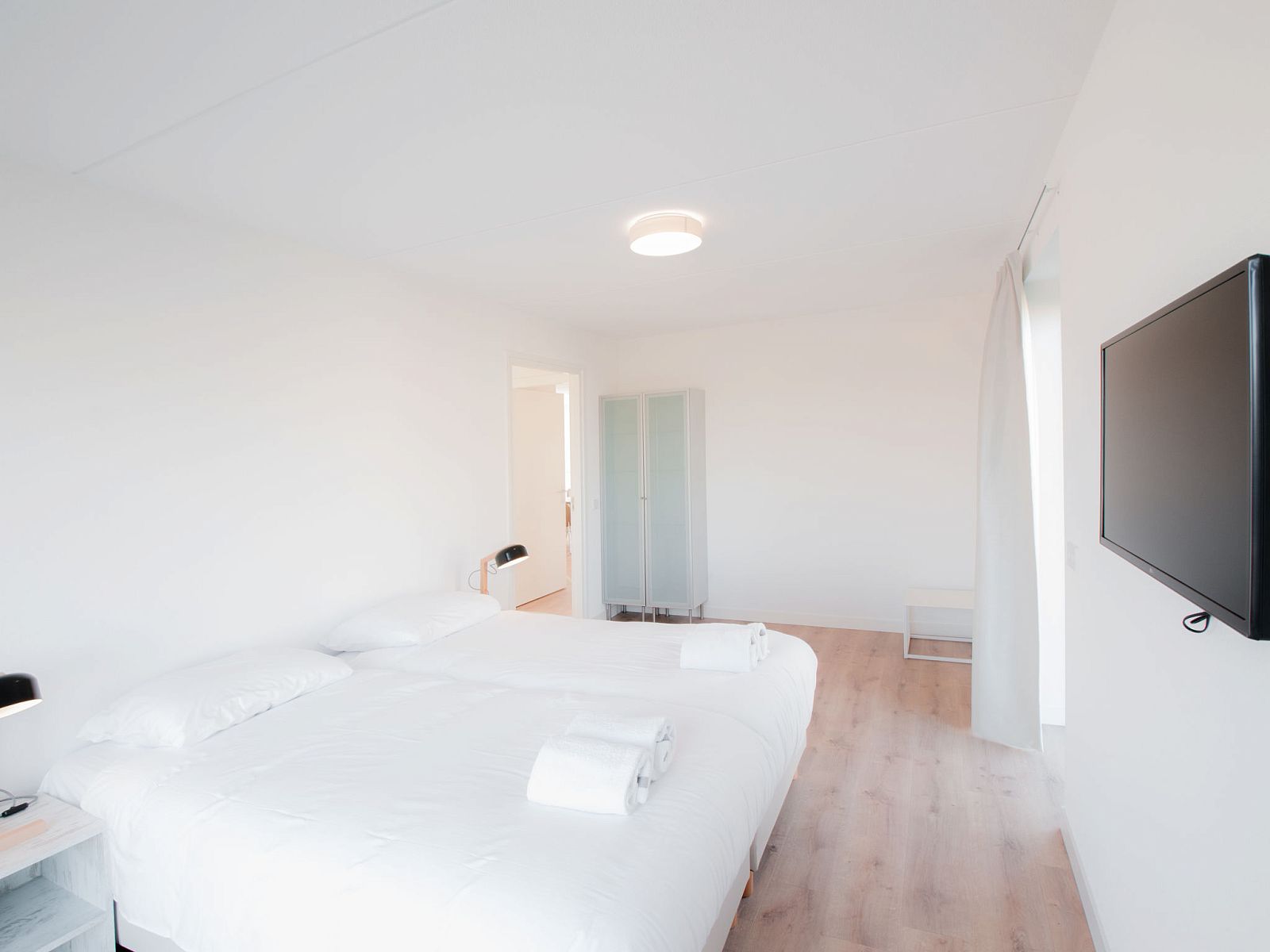 Lichte slaapkamer in Vakantiehuis Oesterdam Resort, Tholen, Zeeland, met tweepersoonsbed en moderne voorzieningen.