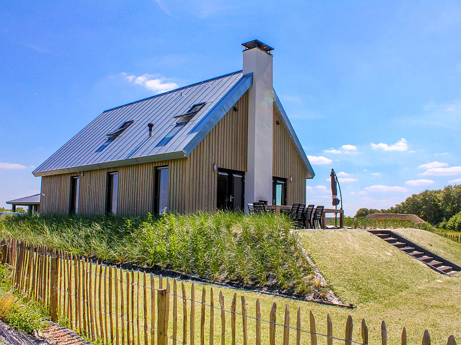 Buitenzijde van Vakantiehuis Oesterdam Resort in Tholen, Zeeland, met terras en groene omgeving.