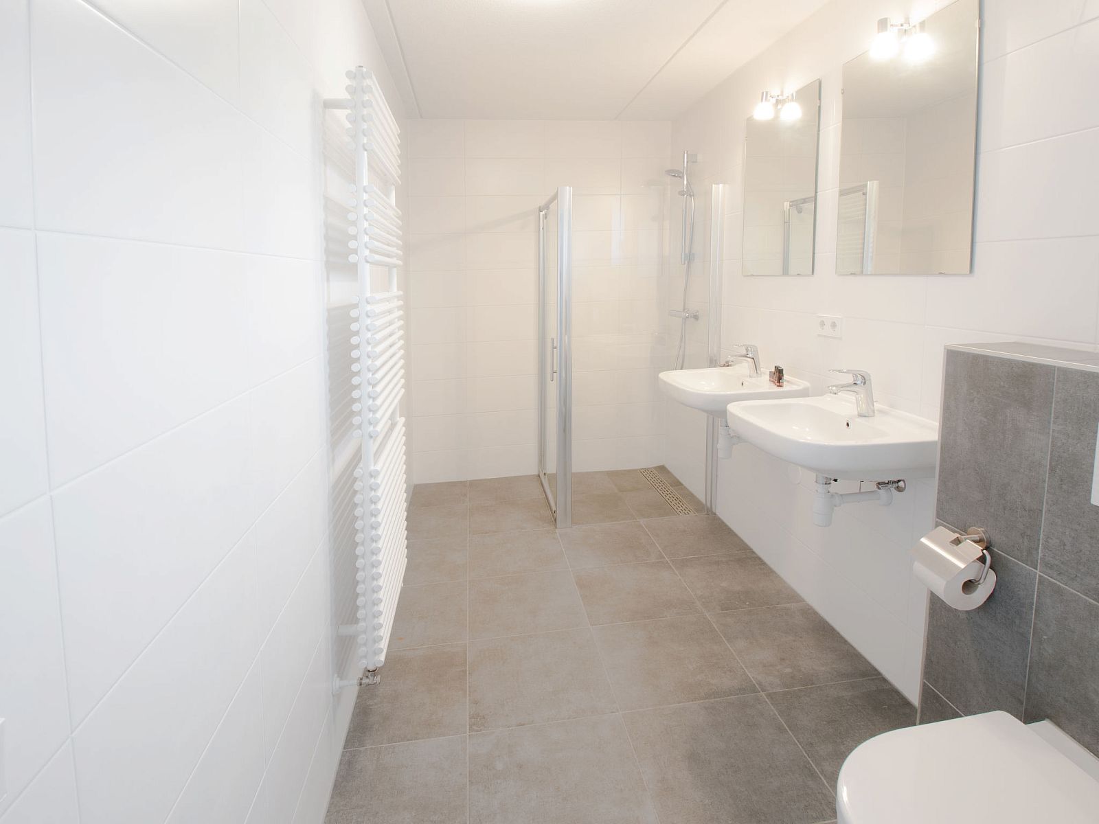 Ruime badkamer met dubbele wastafel in Vakantiehuis Oesterdam Resort, Tholen, Zeeland, voor extra comfort.