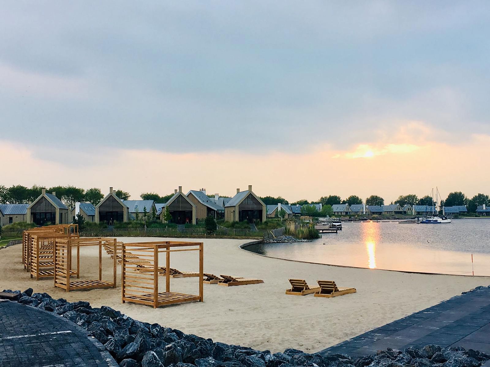 Strand en water bij Vakantiehuis Oesterdam Resort in Tholen, Zeeland bij zonsondergang.
