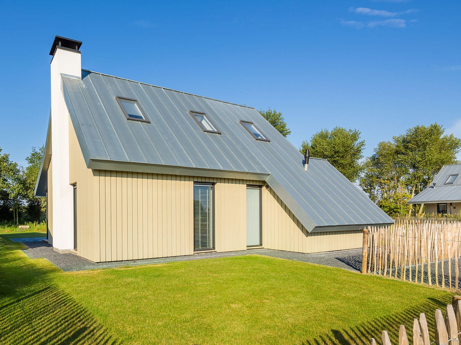 Buitenzijde van Vakantiehuis Oesterdam Resort in Tholen, Zeeland met groene tuin.