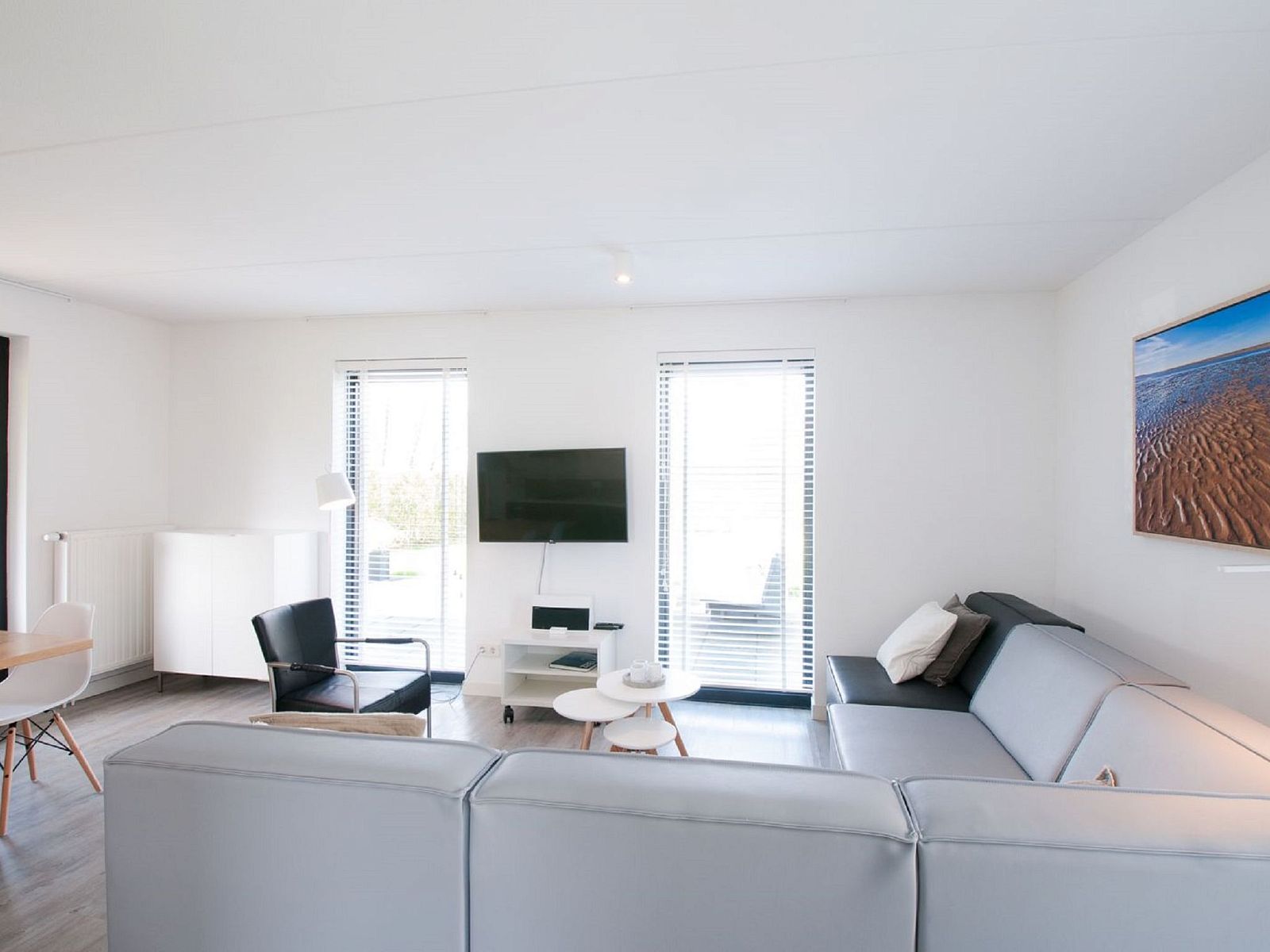 Moderne zithoek met televisie in Vakantiehuis Oesterdam Resort in Tholen, Zeeland.