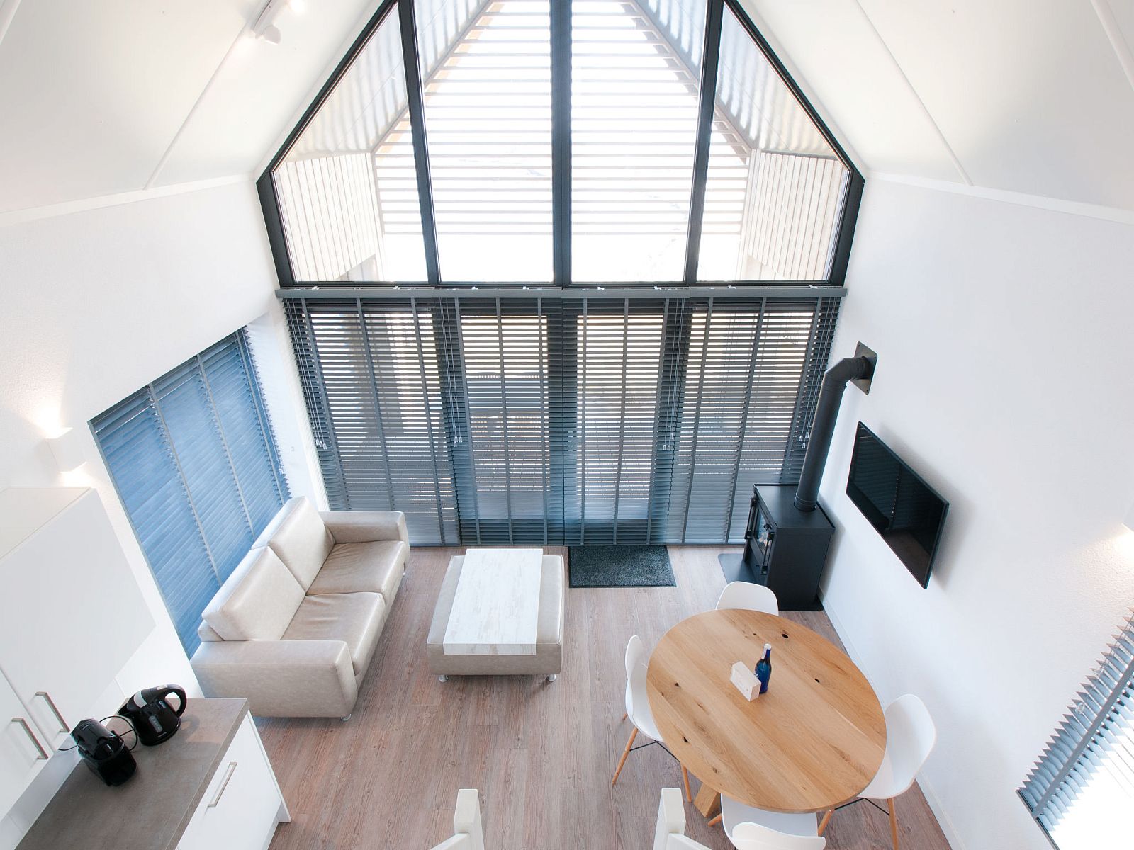 Modernes Interieur des Ferienhauses Oesterdam Resort in Tholen, Zeeland, mit hohen Fenstern.