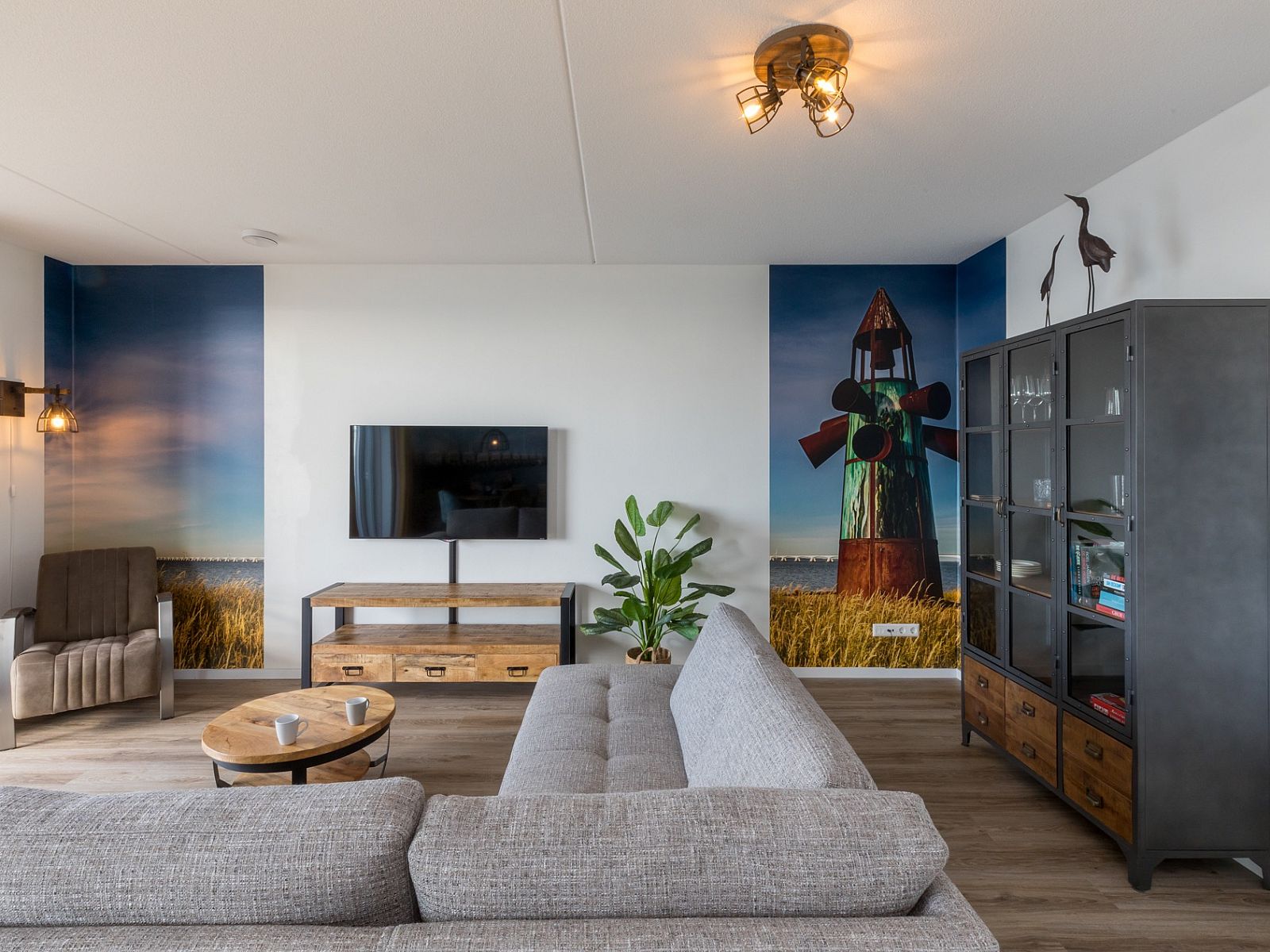 Stijlvolle woonkamer in Appartement in Scherpenisse, Tholen, Zeeland met moderne inrichting en kunst aan de muur.
