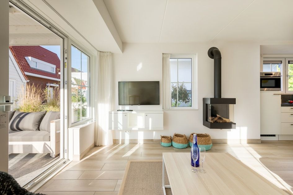 Lichte woonkamer van Banckert Luxe Outdoor 4 vakantiehuis in Koudekerke, Walcheren, Zeeland met moderne inrichting en uitzicht op terras.