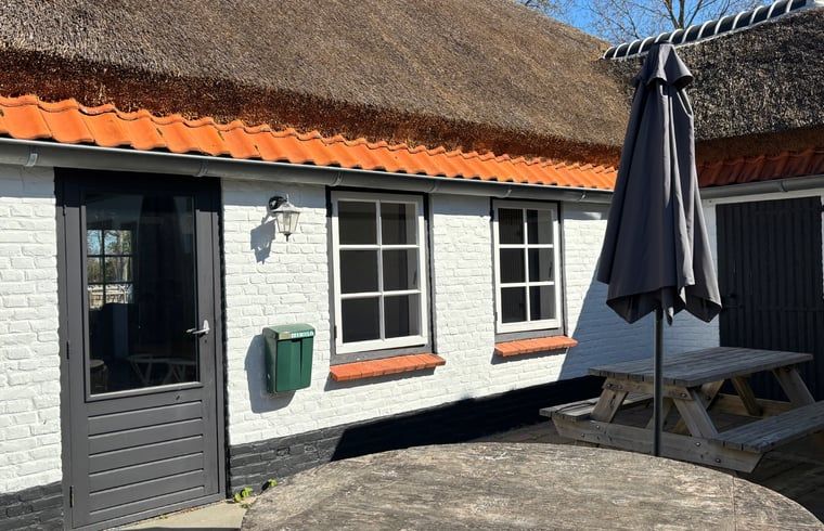 Zonnig terras bij Huisje in Koudekerke, charmant vakantieverblijf in Zeeland.