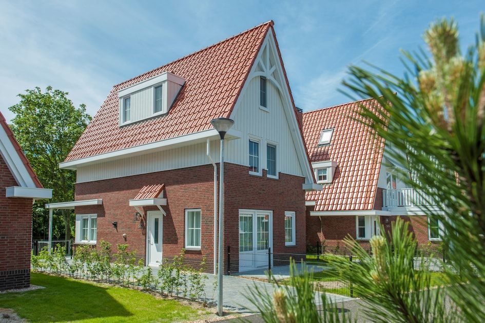 De With Luxe 8 Ferienhaus in Koudekerke, Walcheren, Zeeland mit charmanten roten Dachziegeln und gruener Umgebung.