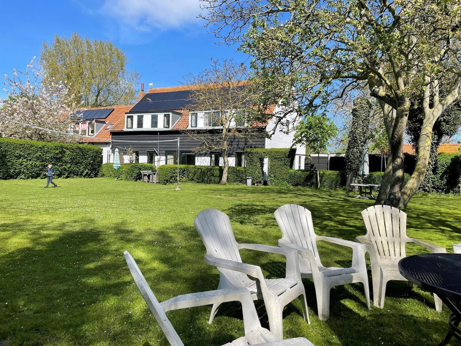 Spacious lawn at VZ034 Apartment Koudekerke, vacation home in Koudekerke, Walcheren, with comfortable chairs in the garden.