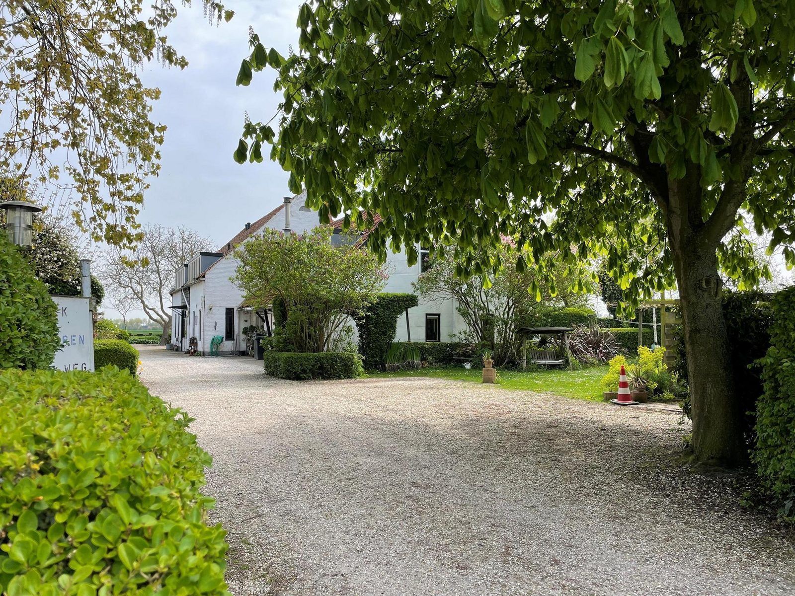 Entrance to VZ034 Apartment Koudekerke, vacation home in Koudekerke, Walcheren, surrounded by greenery and trees.