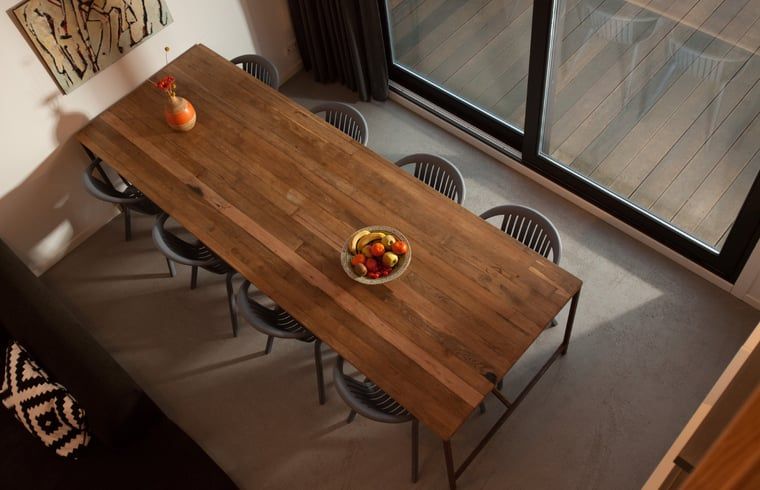 Esszimmer des Ferienhauses in Koudekerke, Walcheren mit Holztisch und moderner Einrichtung.