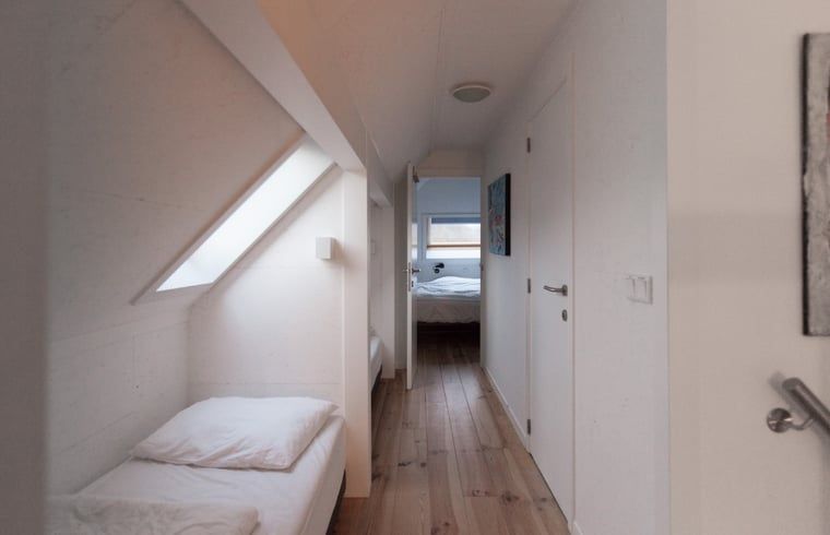 Schlafzimmer mit Holzboden im Ferienhaus in Koudekerke, Zeeland fuer eine gemuetliche Uebernachtung.