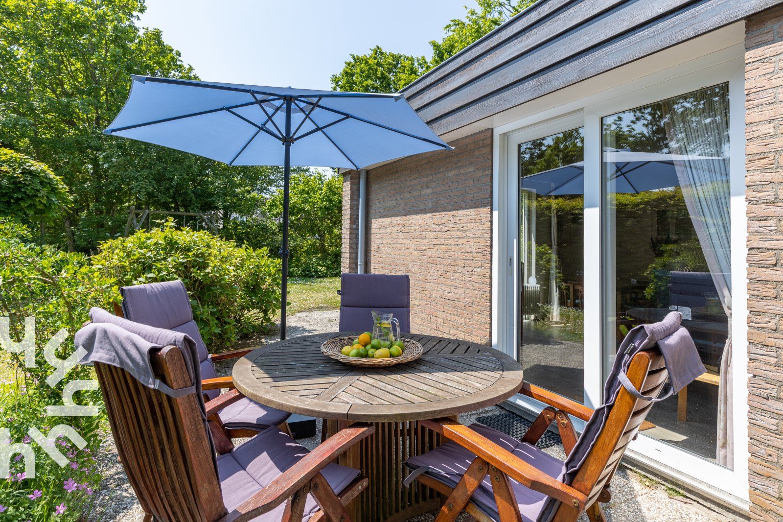 Veranda van vakantiehuis ZE098 in Oostkapelle, Walcheren, met comfortabele stoelen en parasol.