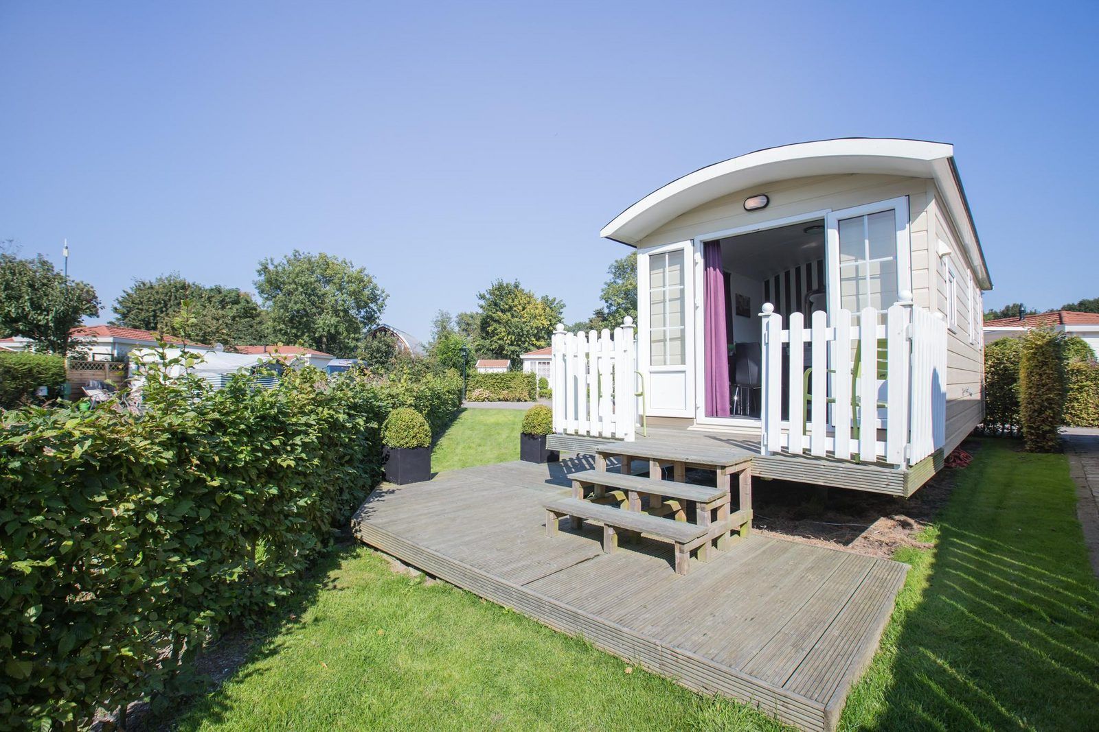 VZ985 Pipowagen in Oostkapelle met zonnig terras en groene omgeving in Walcheren, Zeeland.
