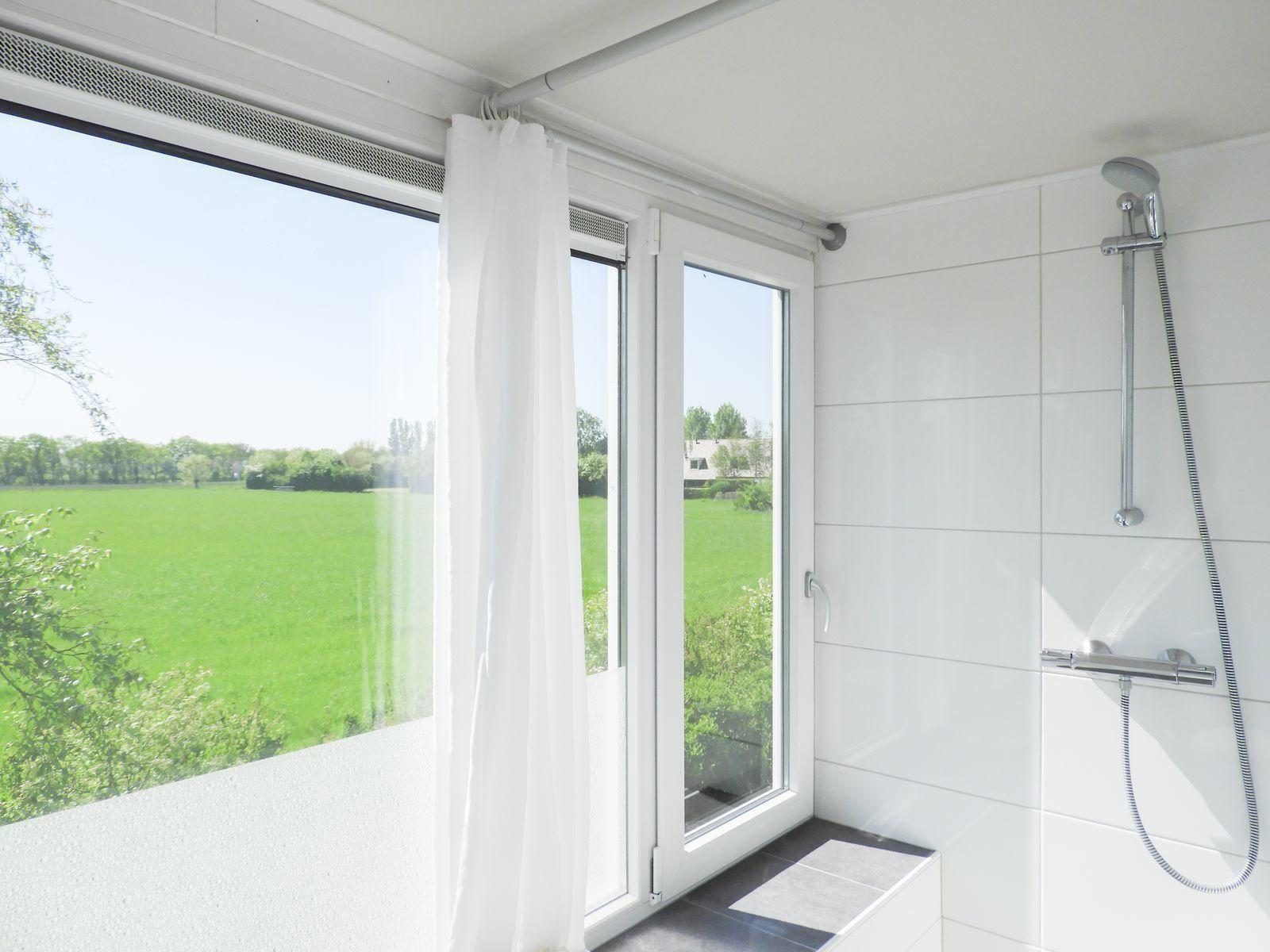 Badezimmer in VZ488 Ferienhaus Oostkapelle mit Blick auf gruene Felder.
