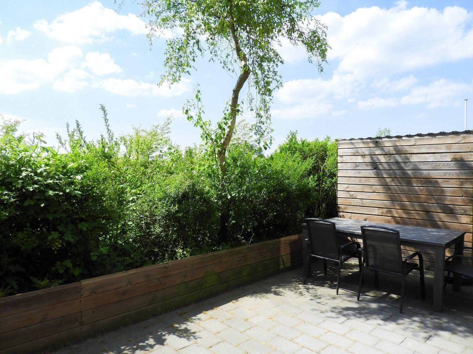 Private Terrasse mit gruenem Zaun am VZ488 Ferienhaus Oostkapelle.