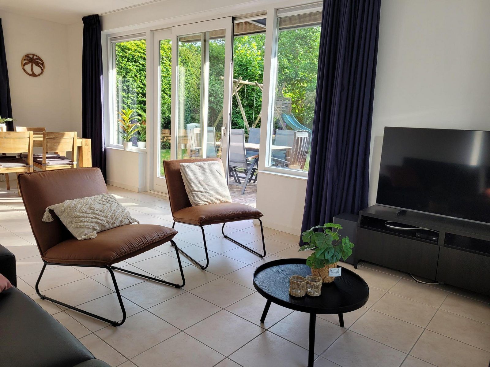 Lichte woonkamer met uitzicht op tuin in VZ2330 Vakantiehuis Oostkapelle, Walcheren, Zeeland.