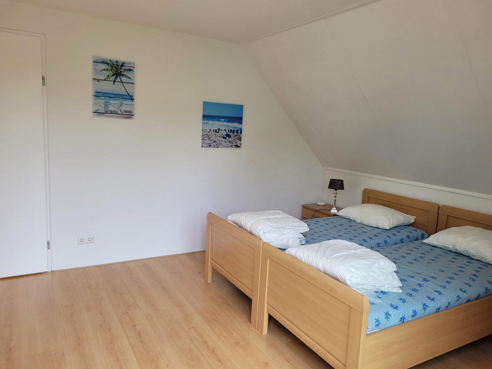 Ruime slaapkamer met kunst aan de muur in VZ2330 Vakantiehuis Oostkapelle, Walcheren, Zeeland.