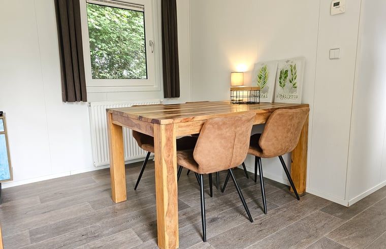 Eethoek in Huisje in Oostkapelle, Walcheren, met houten tafel en stijlvolle stoelen.