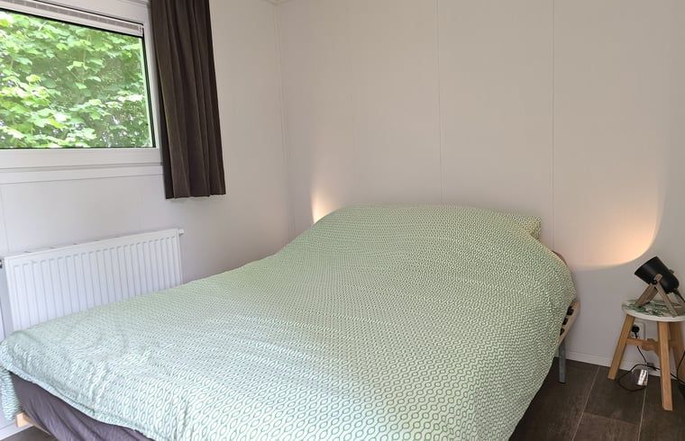 Slaapkamer in Huisje in Oostkapelle, Walcheren, met comfortabel tweepersoonsbed.