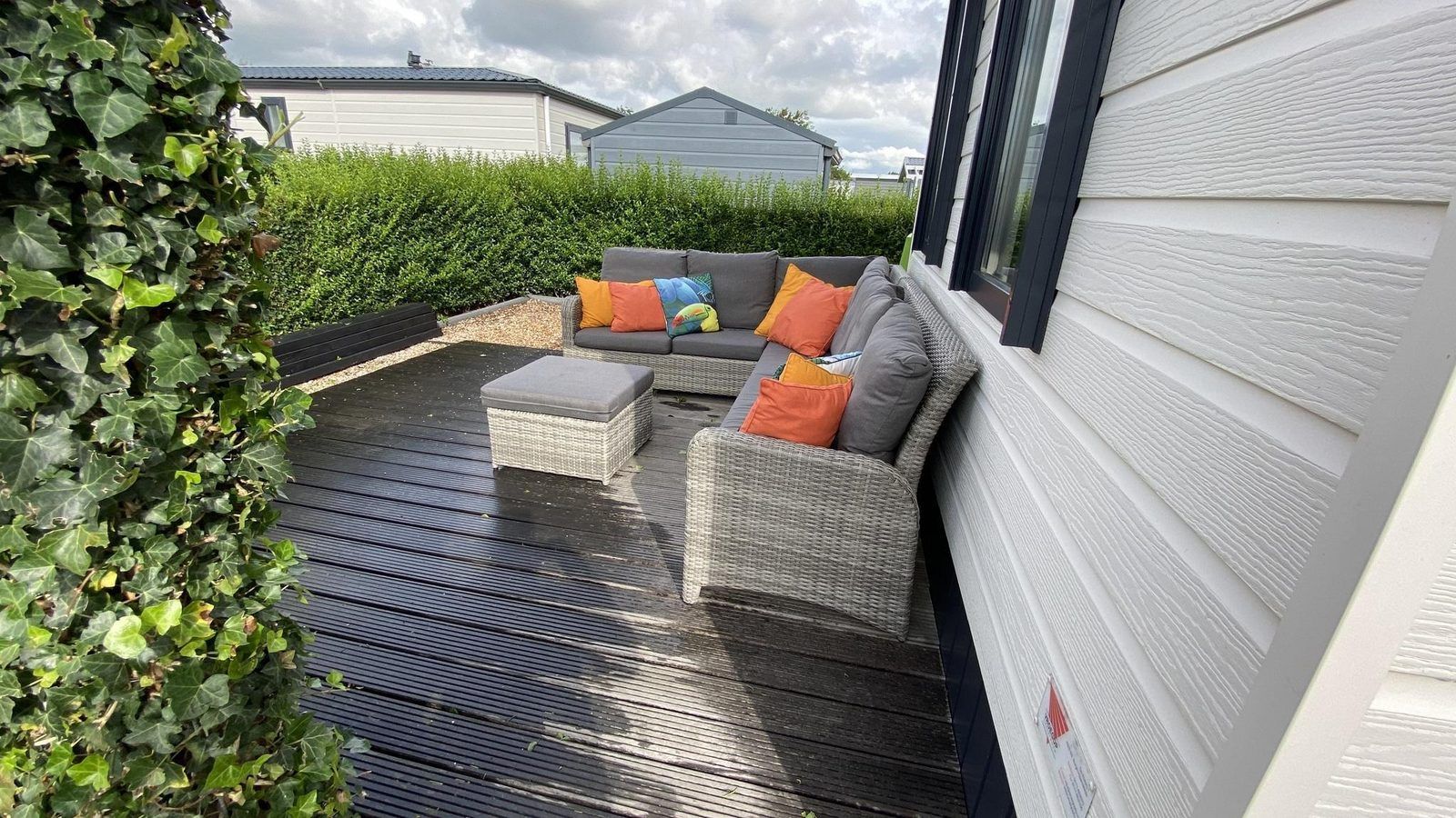 Aussensitzbereich im VZ882 Ferienhaus Oostkapelle mit bunten Kissen.