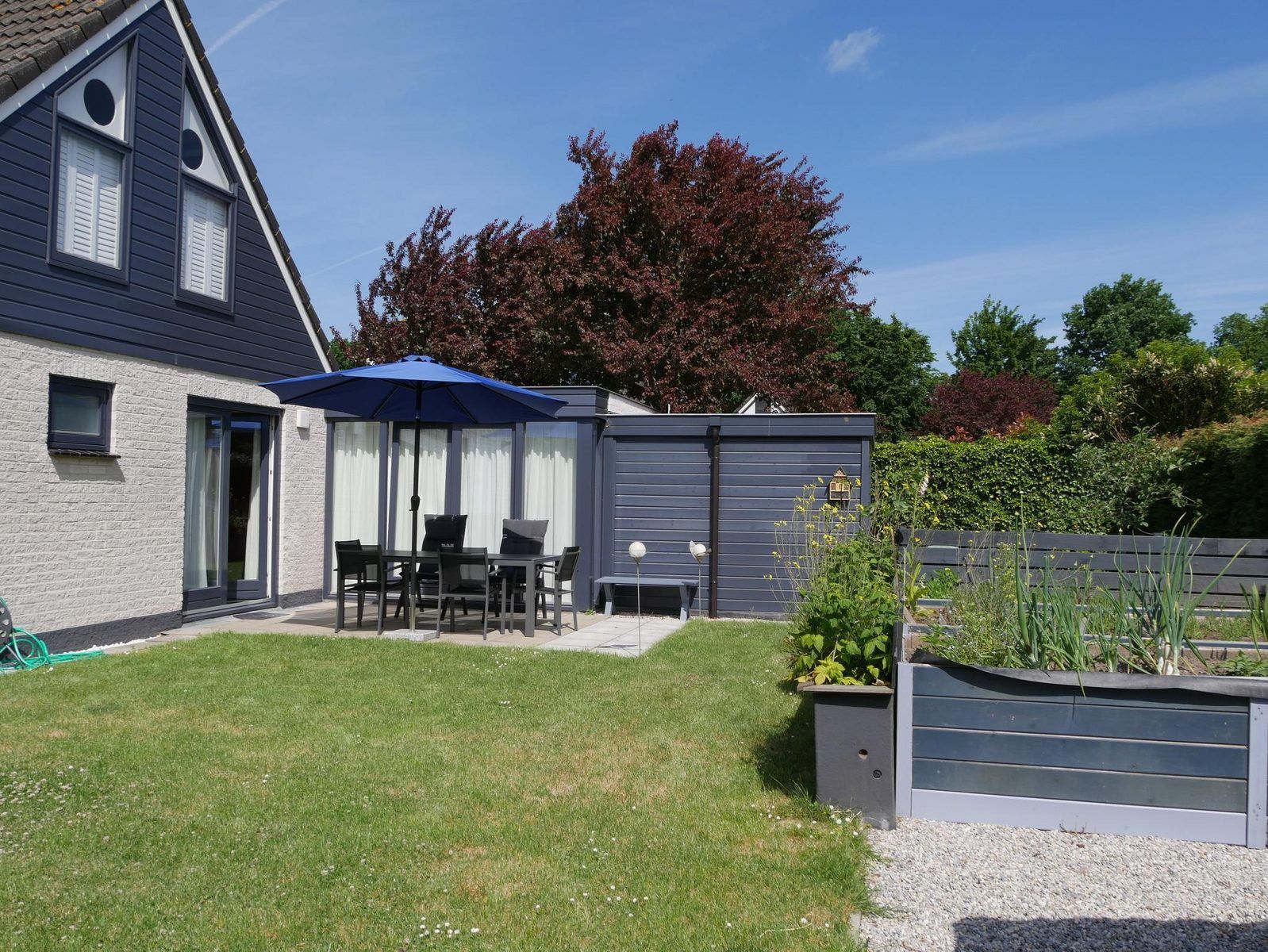 Geniet van de zonnige tuin met terras bij VZ1175 Vakantiehuis in Oostkapelle, Walcheren, Zeeland.