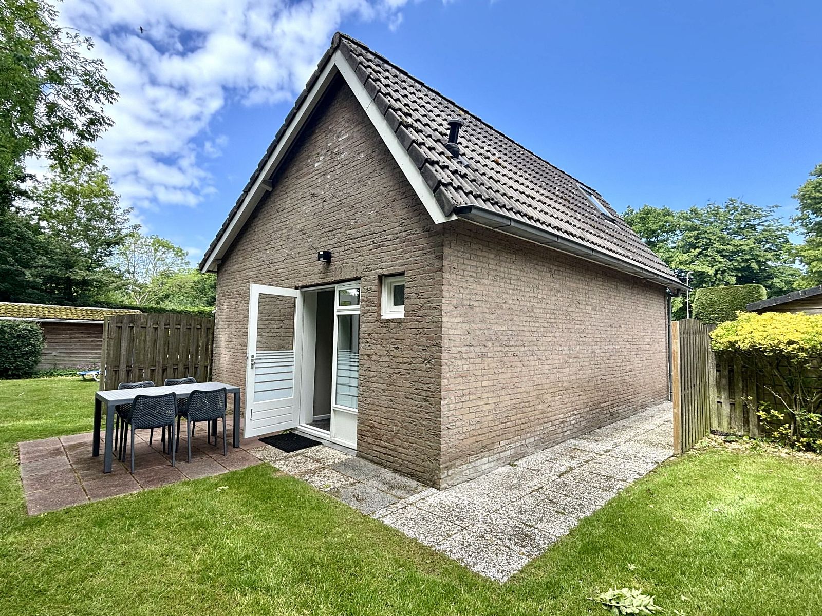 Achtertuin met zitje bij Appartement Boszicht 6 in Oostkapelle, Walcheren, Zeeland.
