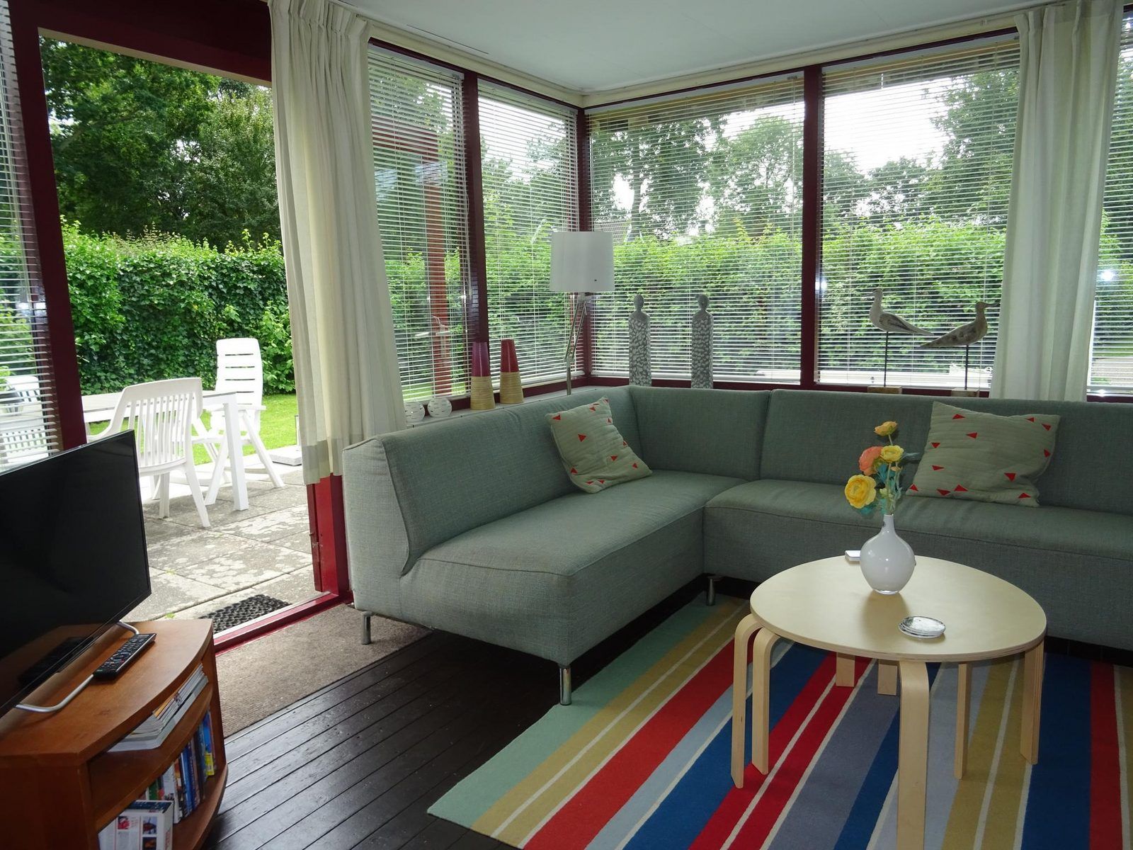 Lichte woonkamer in VZ1184 Vakantiebungalow, Oostkapelle, met uitzicht op de tuin in Walcheren, Zeeland.