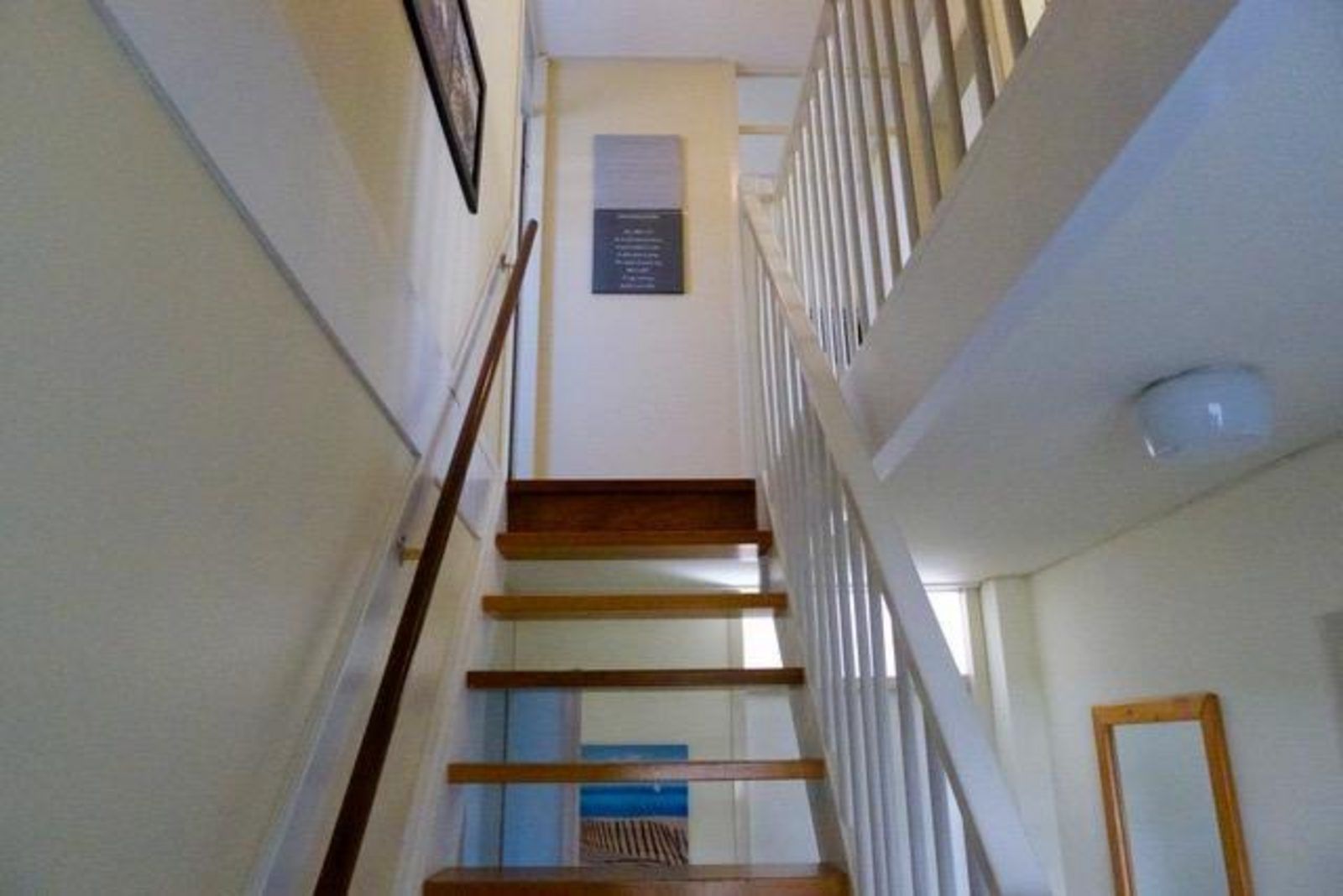 Treppe zum Obergeschoss im Ferienhaus VZ2416, Oostkapelle, Walcheren, mit heller Wand und Malerei.