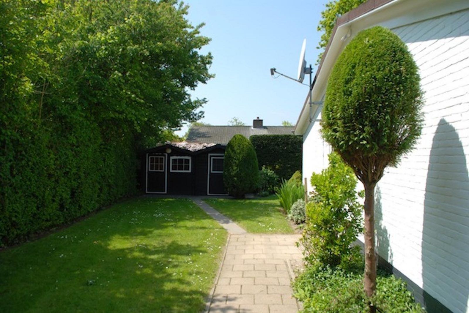 Backyard with path to barn at VZ1163 Holiday bungalow in Oostkapelle, Walcheren, Zeeland.