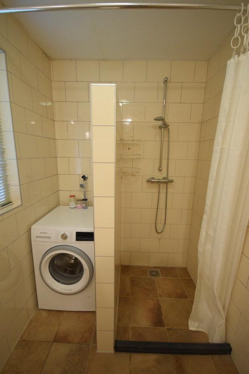 Badezimmer in VZ2329 Ferienhaus Oostkapelle mit moderner Dusche und Waschmaschine, Zeeland.