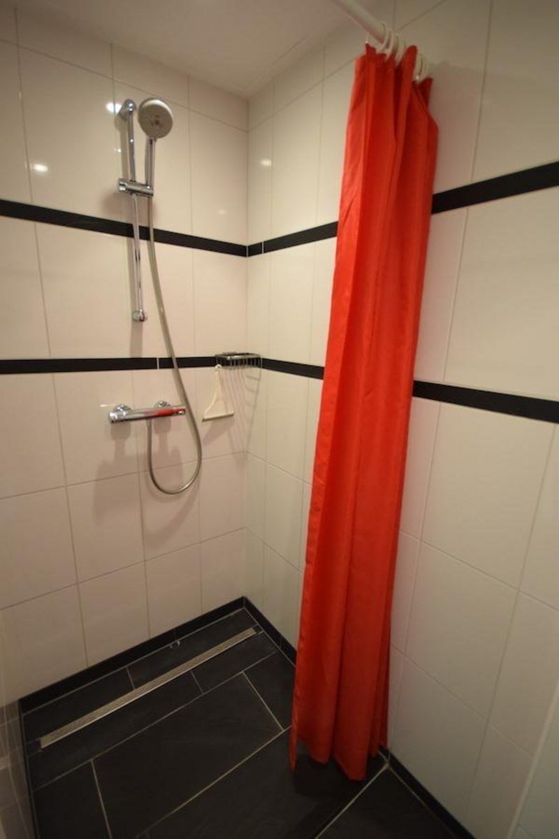 Dusche in VZ1185 Ferienbungalow in Oostkapelle mit rotem Vorhang in Walcheren, Zeeland.