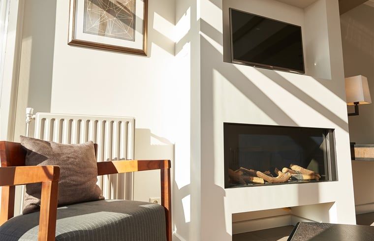 Gemuetliche Sitzecke mit Kamin im Ferienhaus in Oostkapelle, Walcheren, Zeeland.