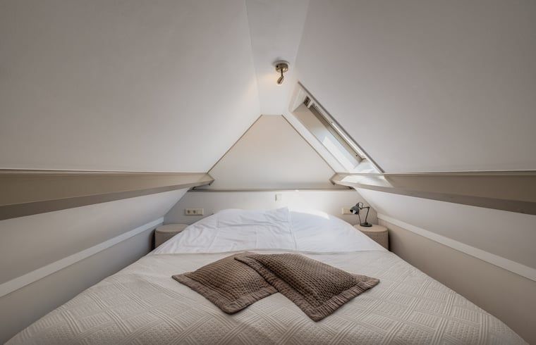 Gemuetliches Schlafzimmer unter dem Dach im Ferienhaus in Oostkapelle, Walcheren, Zeeland.