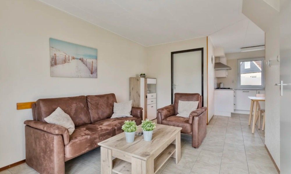 Gezellige woonkamer in Vakantiewoning Oostkapelle, Walcheren, met comfortabele zitruimte en moderne keuken, op slechts 800 m van het strand.