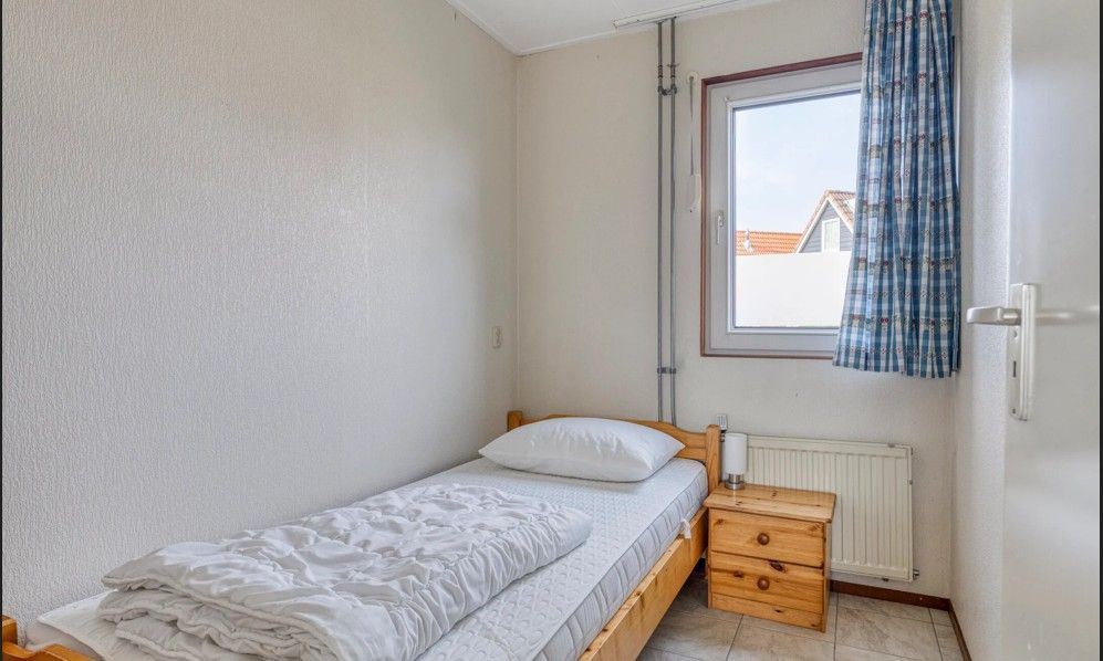 Knusse slaapkamer in Vakantiewoning Oostkapelle, Walcheren, Zeeland, met een comfortabel eenpersoonsbed en uitzicht op de omgeving.