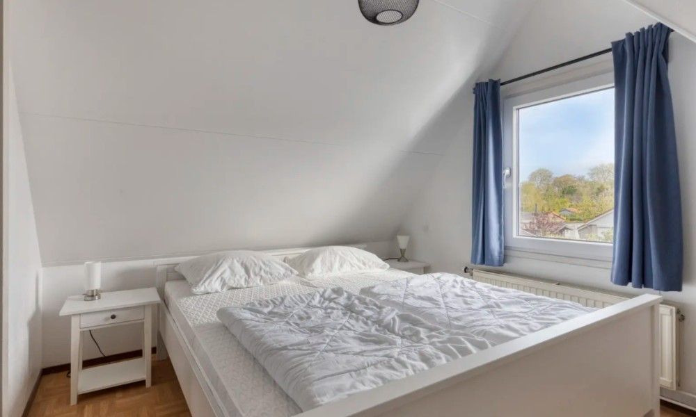 Slaapkamer in Vakantiewoning Oostkapelle, Walcheren, met comfortabel bed en uitzicht op de natuur, op 800 m van het strand in Zeeland.