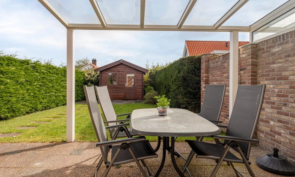 Ontspan op het overdekte terras van Vakantiewoning Oostkapelle, een vakantiehuis in Oostkapelle, Walcheren, Zeeland, nabij het strand.