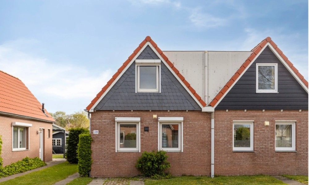 Charmant vakantiehuis Vakantiewoning Oostkapelle in Walcheren, Zeeland, op 800 m van het strand, met een uitnodigende gevel en groene omgeving.
