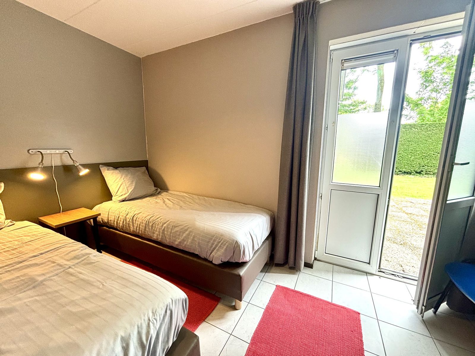 Bedroom with two beds in Apartment Boszicht 1, Oostkapelle, Walcheren, with access to the garden.